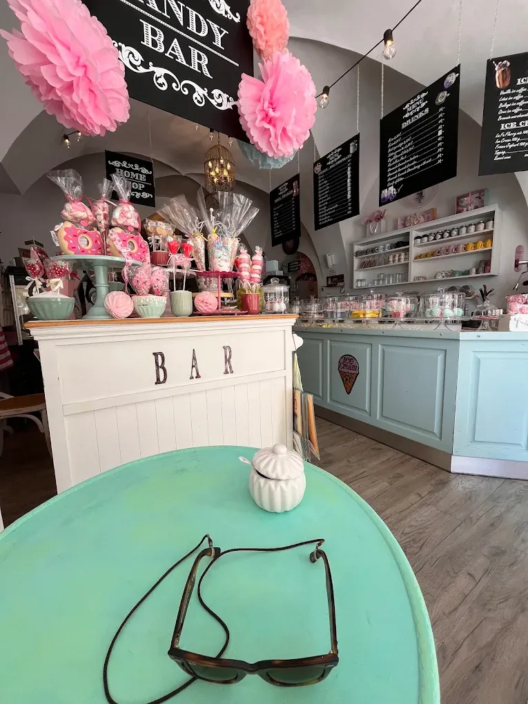 Candy bar s cukrovinkami v pastelovém interiéru kavárny